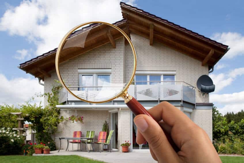 a person holding a magnifying glass up to a house