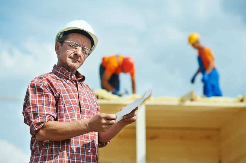 A roofing contractor holding a clip board during a roof estimate. 